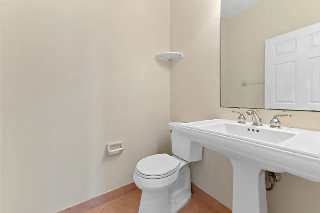 a bathroom with a sink a toilet and mirror
