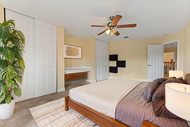 a bedroom with a bed and a potted plant