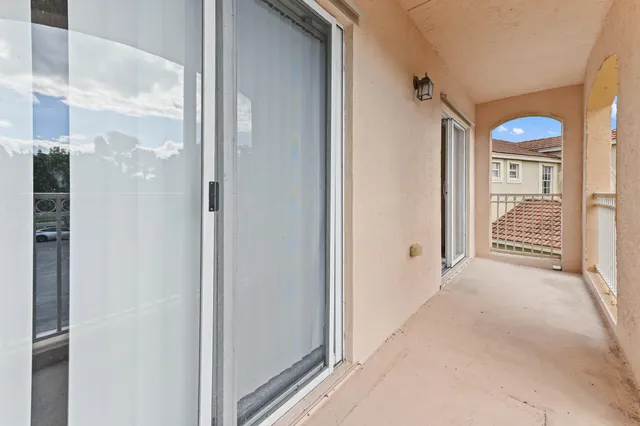 a view of a hallway with wooden floor and windows