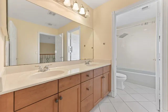 a bathroom with a granite countertop sink a toilet and a mirror
