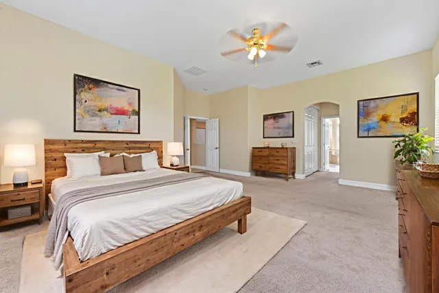a spacious bedroom with a bed and a painting on the wall