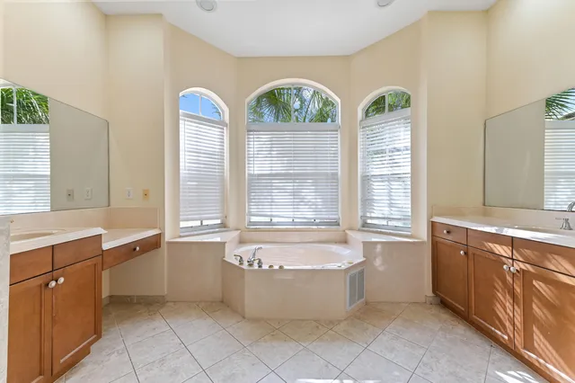 a view of spacious bathroom with bathtub and window