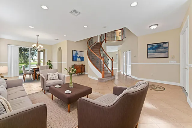 a living room with couches and kitchen view with wooden floor