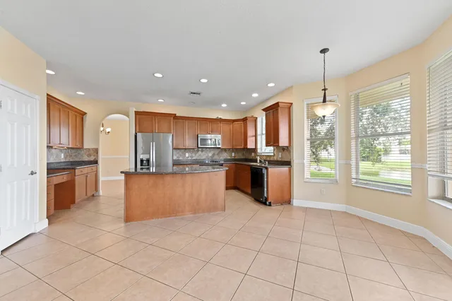 a large kitchen with kitchen island granite countertop a large counter top stainless steel appliances and cabinets
