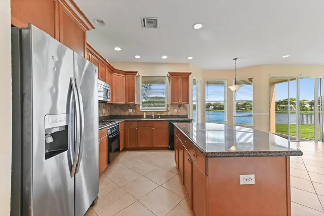 a kitchen with stainless steel appliances granite countertop a refrigerator a sink and a stove