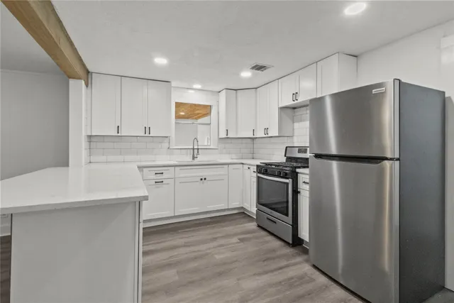 a kitchen with a refrigerator sink and cabinets