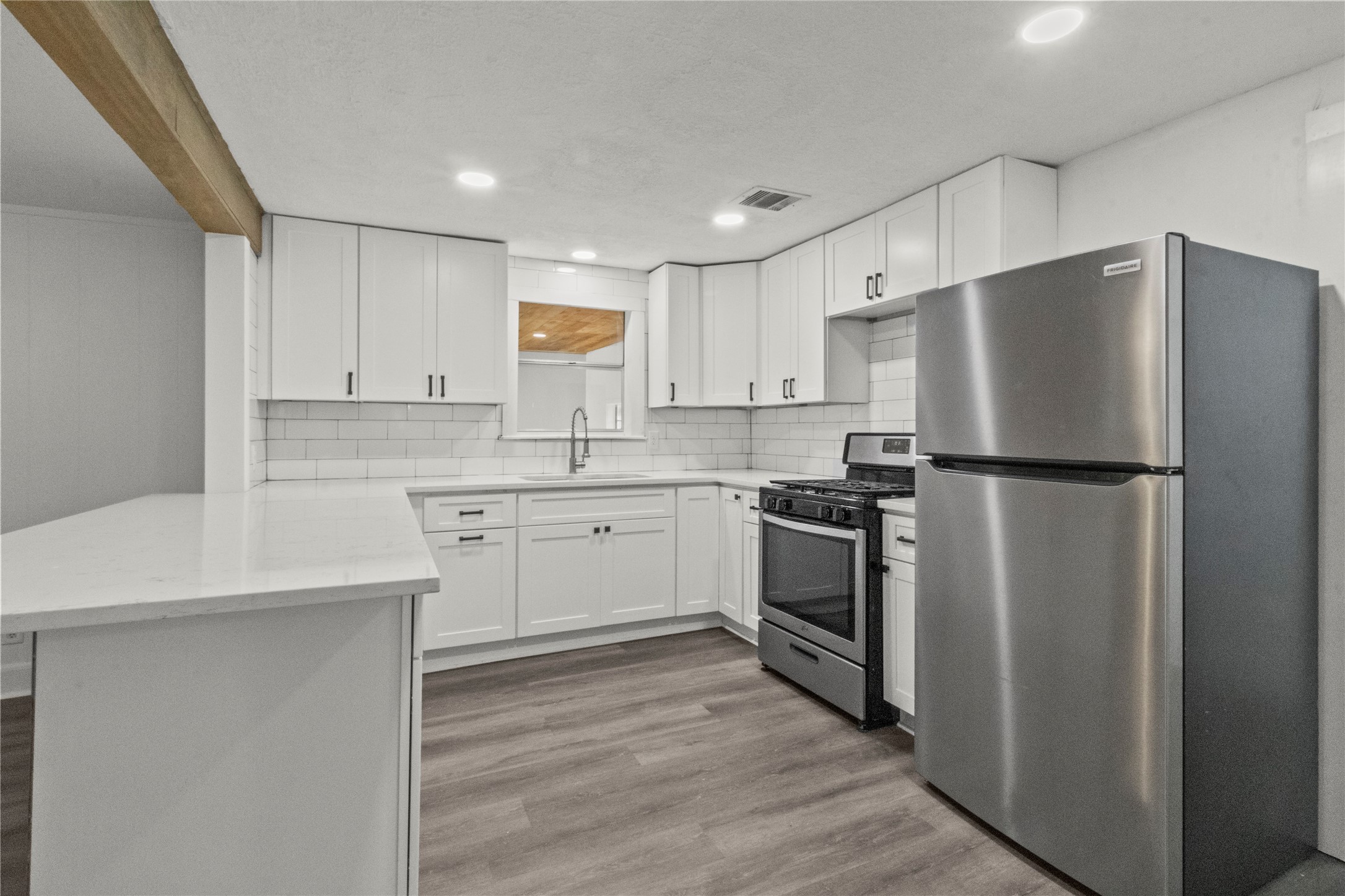 a kitchen with a refrigerator sink and cabinets