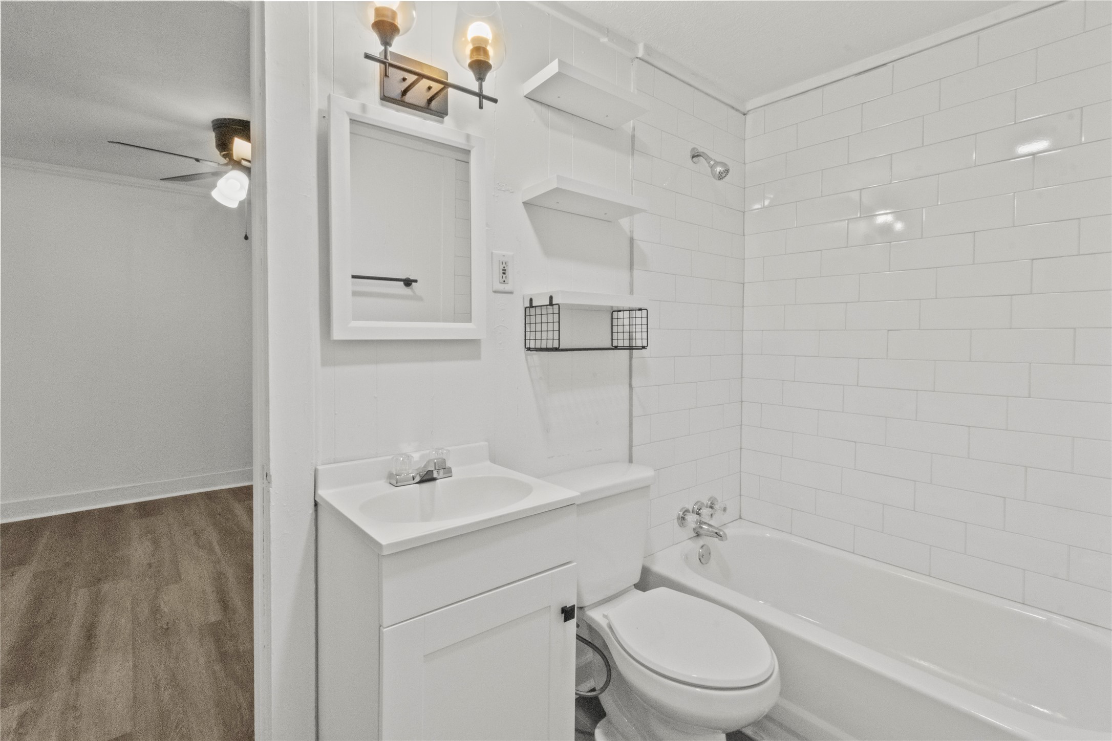 802 Collins Street Dayton, TX 77535 - Photo 4 of 12 a bathroom with a toilet sink a mirror and shower