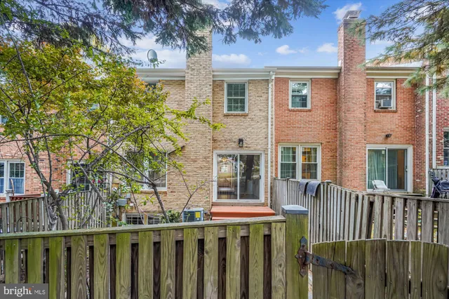 a front view of a house with a tree