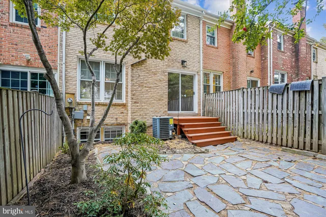 a backyard of a house with barbeque oven and a table and chairs