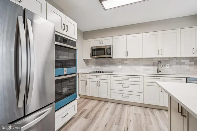 a kitchen with cabinets stainless steel appliances and a counter space