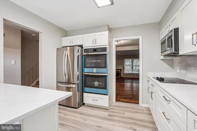a kitchen with stainless steel appliances a refrigerator and a stove top oven