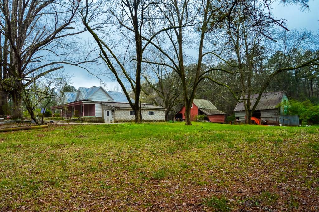 a view of a house with a yard and tree s