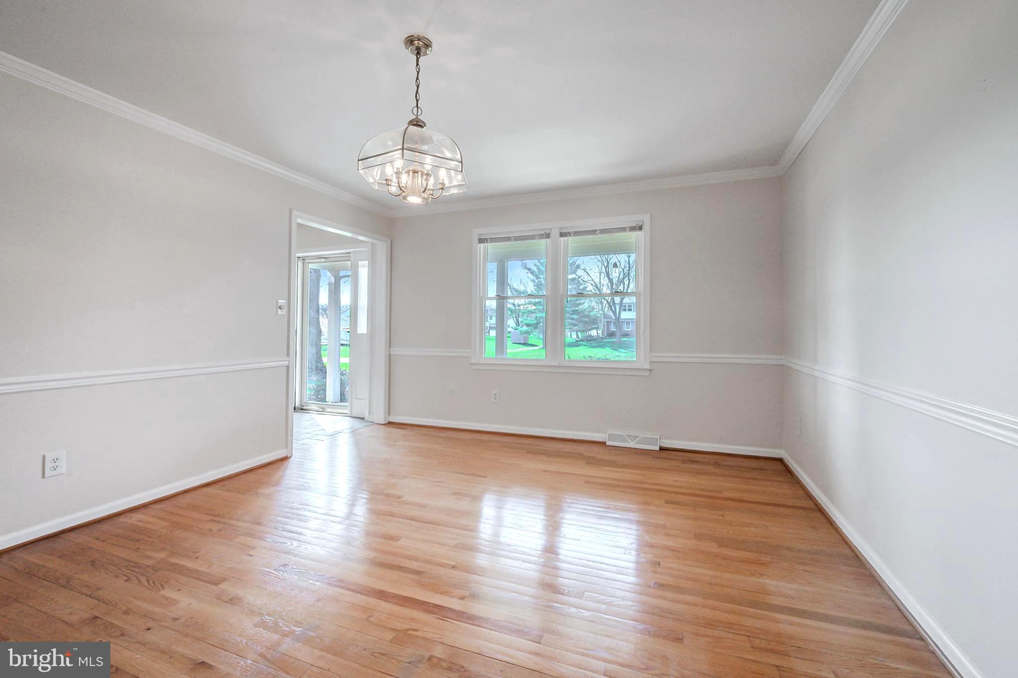 4 Phoenix Drive Bear, DE 19701 - Photo 6 of 21 an empty room with wooden floor chandelier and windows