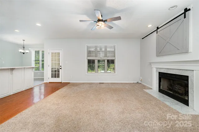 a view of an empty room with a fireplace and a window