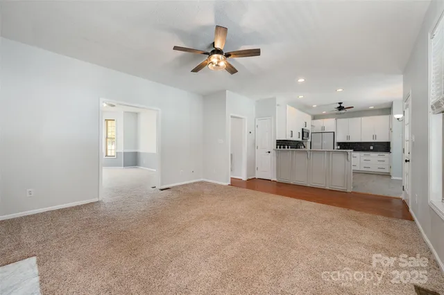 a view of a kitchen with a sink and dishwasher a refrigerator with white cabinets