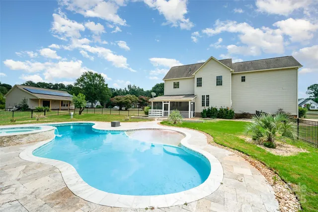 a view of a house with swimming pool and a yard