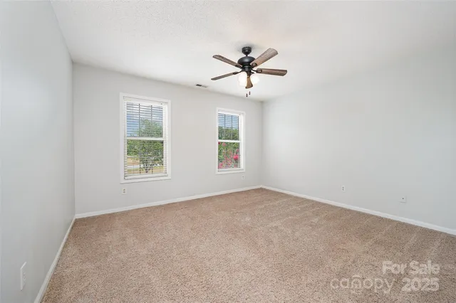 a view of a yard in front of a house with large trees
