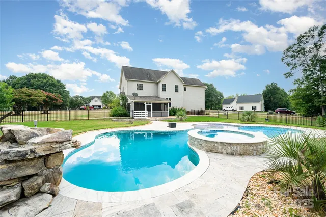 a view of a house with swimming pool and yard