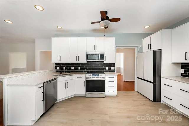 a kitchen with stainless steel appliances granite countertop a refrigerator and a stove top oven