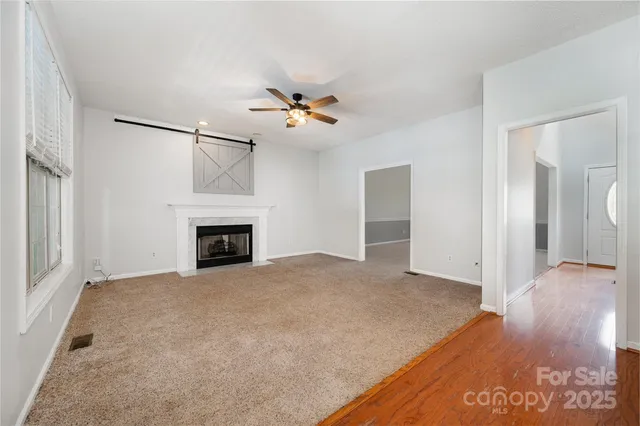 a view of an empty room with a fireplace and a window