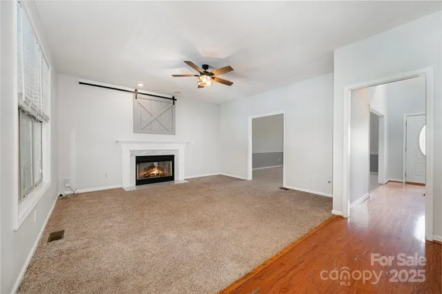 a view of an empty room with a fireplace and a window