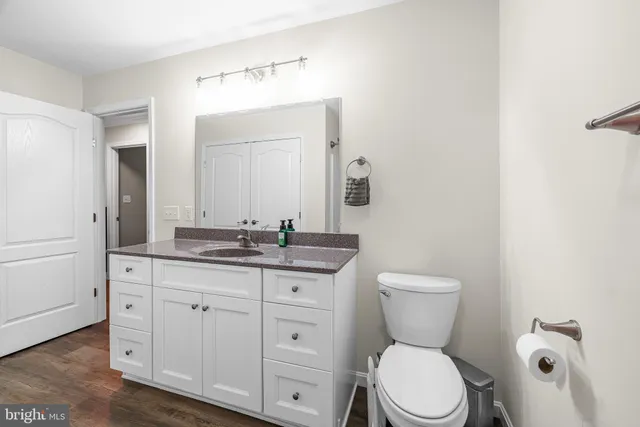 a bathroom with a granite countertop toilet sink and mirror