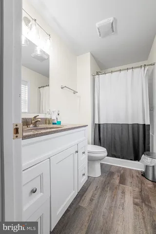 a bathroom with a toilet a sink a mirror a shower and vanity