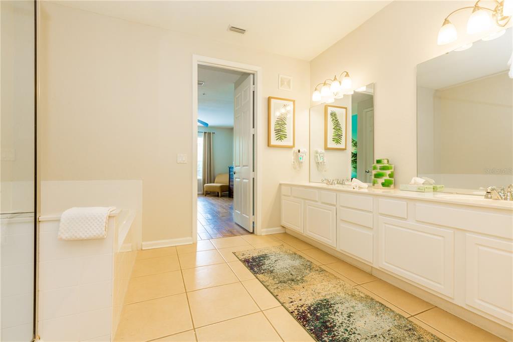 5025 Shoreway Loop, Unit 105 Orlando, FL 32819 - Photo 16 of 55 a spacious bathroom with a sink a mirror and a bathtub