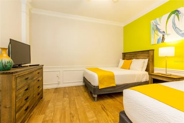 a bedroom with two beds and painting on the wall