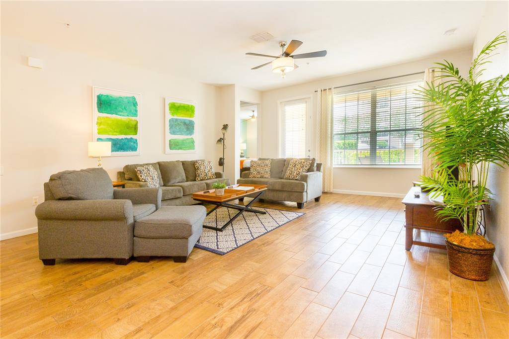 5025 Shoreway Loop, Unit 105 Orlando, FL 32819 - Photo 5 of 55 a living room with furniture and a potted plant