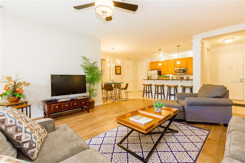 5025 Shoreway Loop, Unit 105 Orlando, FL 32819 - Photo 7 of 55 a living room with furniture and a flat screen tv with kitchen view