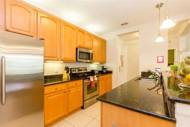 a kitchen with stainless steel appliances granite countertop a sink a stove and a refrigerator