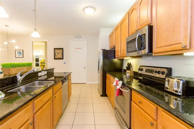 a kitchen with stainless steel appliances a sink stove and refrigerator