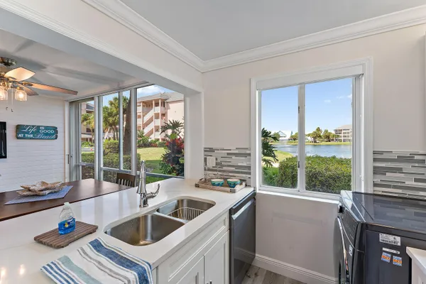 a kitchen that has a sink and a view of living room