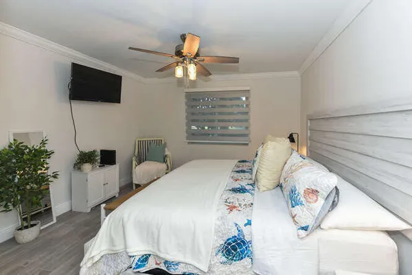 a bedroom with a bed and a flat screen tv