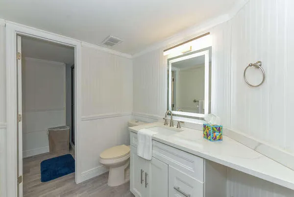 a bathroom with a granite countertop toilet sink and a mirror