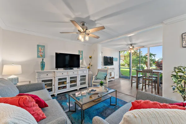 a living room with furniture a flat screen tv and a large window