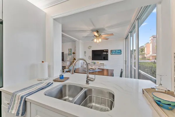 a kitchen with a sink and a flat screen tv