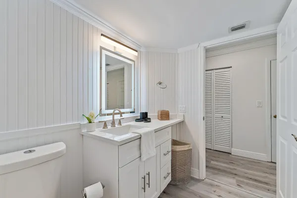 a bathroom with a sink a toilet and a mirror