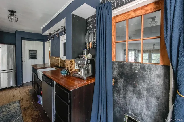 a kitchen with a counter space a sink and stainless steel appliances