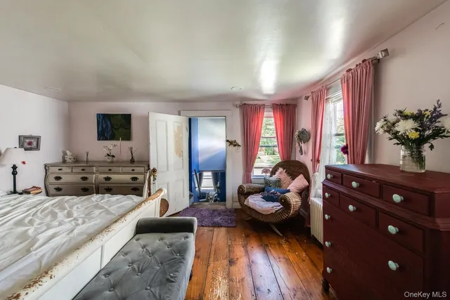 a bedroom with a bed and a lamp on dresser