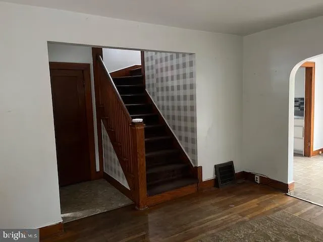 an entryway in a room with wooden floor and stairs