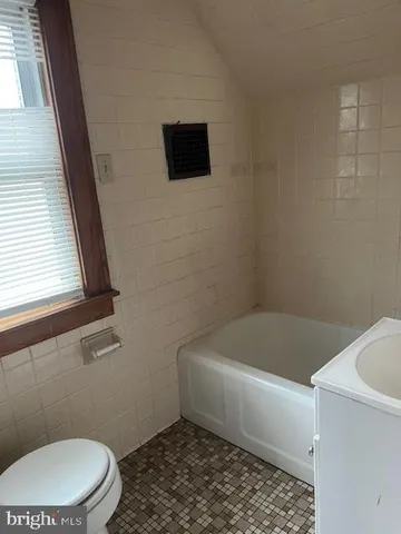 a bathroom with a toilet a sink and bathtub