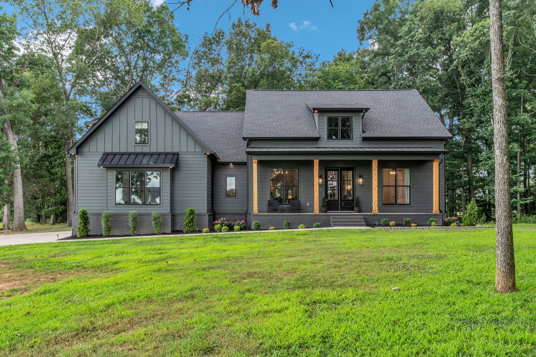 a front view of a house with a yard and trees