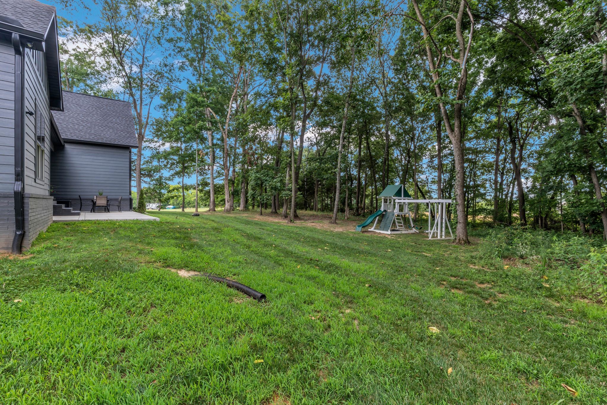 8921 Cedar Grove Road Cross Plains, TN 37049 - Photo 46 of 50 a view of a wooden house with a big yard and large trees