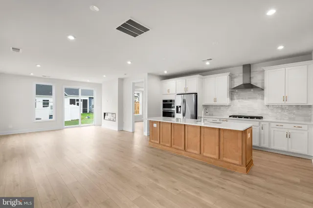 a large kitchen with stainless steel appliances granite countertop a lot of counter space and wooden floor