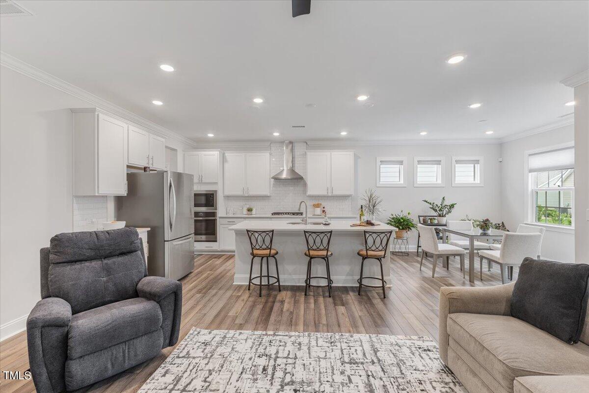 213 Mahogany Run Raleigh, NC 27610 - Photo 12 of 40 a living room with furniture kitchen view and a wooden floor