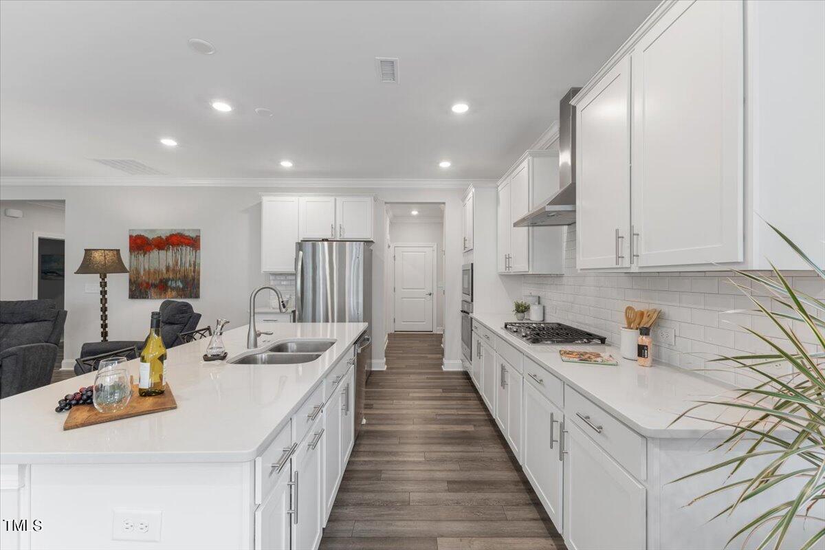 213 Mahogany Run Raleigh, NC 27610 - Photo 14 of 40 a kitchen with stainless steel appliances kitchen island granite countertop a sink and cabinets