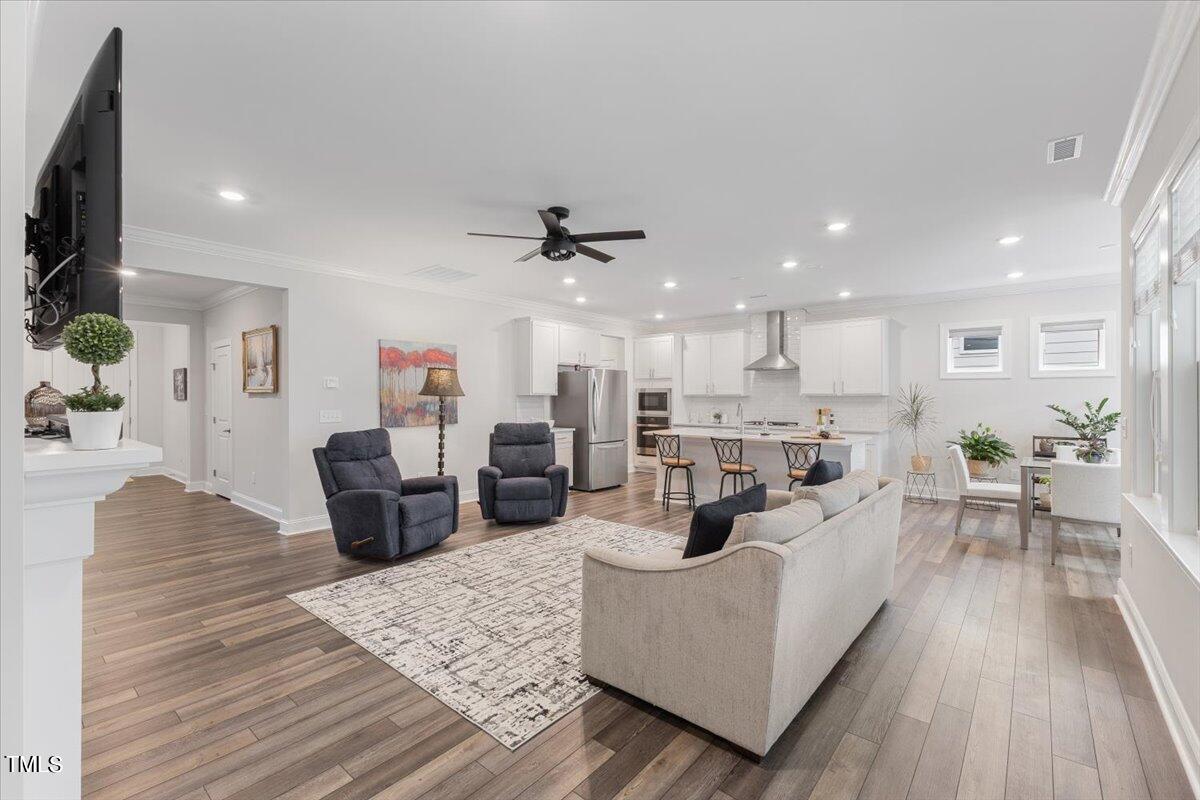 213 Mahogany Run Raleigh, NC 27610 - Photo 9 of 40 a living room with furniture kitchen view and a wooden floor